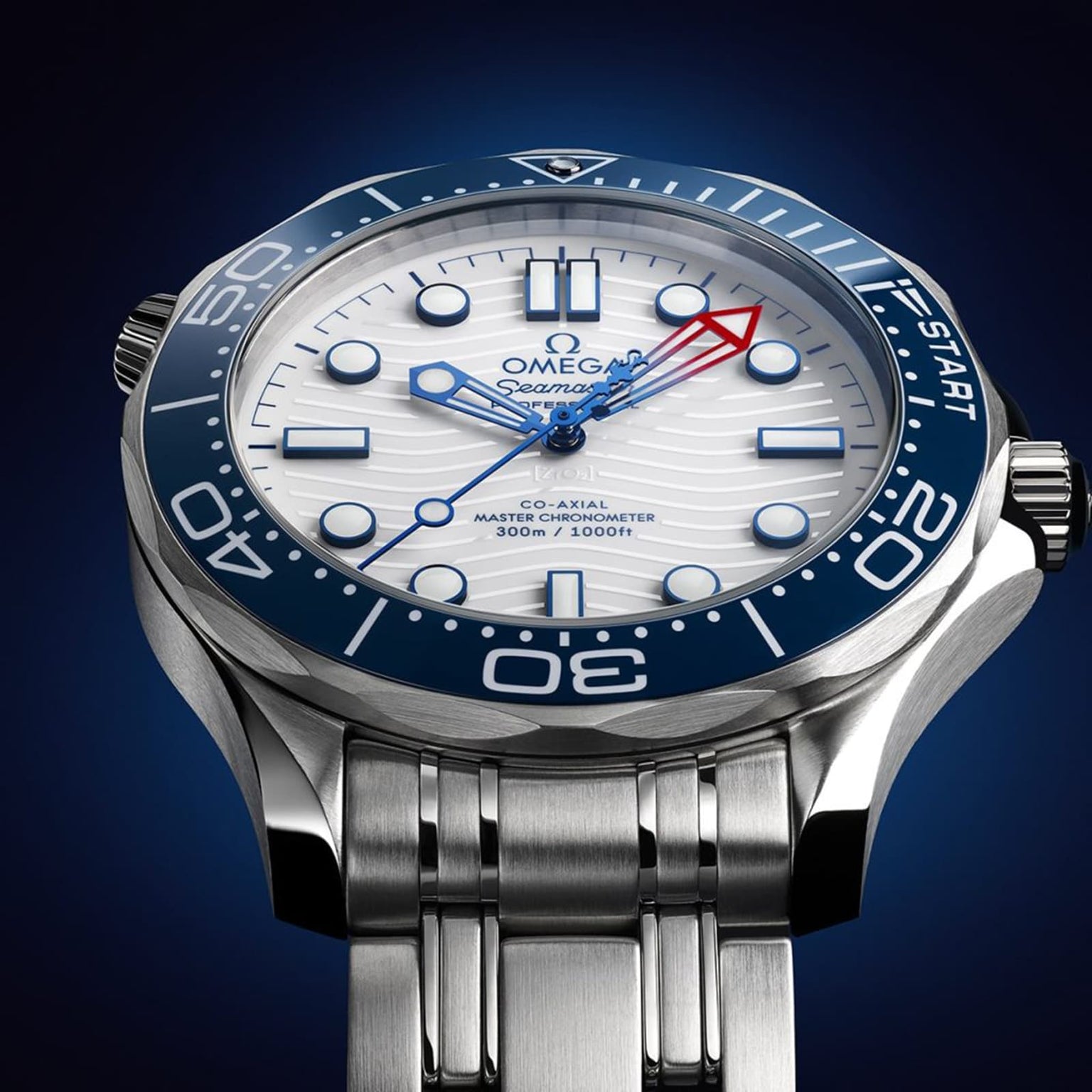 Close-up of the OMEGA Seamaster Diver Americas Cup 300M, showcasing a white textured dial, blue regatta bezel, and red-tipped second hand. Powered by the Co-Axial Master Chronometer Calibre 8806, set against a dark blue backdrop.