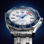 Close-up of the OMEGA Seamaster Diver Americas Cup 300M, showcasing a white textured dial, blue regatta bezel, and red-tipped second hand. Powered by the Co-Axial Master Chronometer Calibre 8806, set against a dark blue backdrop.