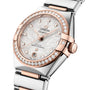 A close-up of an OMEGA Constellation watch featuring a silver dial, diamond hour markers, and a two-tone stainless steel and rose gold bracelet.