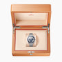 An OMEGA Speedmaster Moonphase Meteorite wristwatch is displayed inside an open light wood OMEGA-branded presentation box.