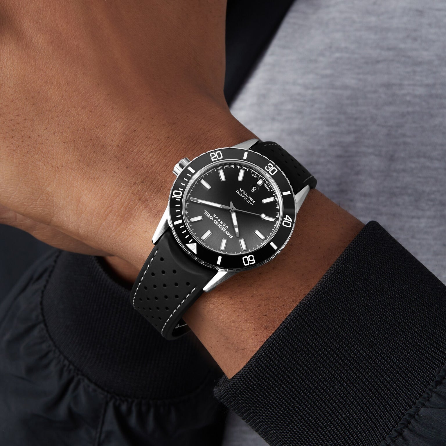A person wearing the Raymond Weil Freelancer Diver Black Dial wristwatch, featuring a minimalistic black dial with white markers, rotating bezel, black strap, and precise timekeeping—ideal for affordable luxury seekers.
