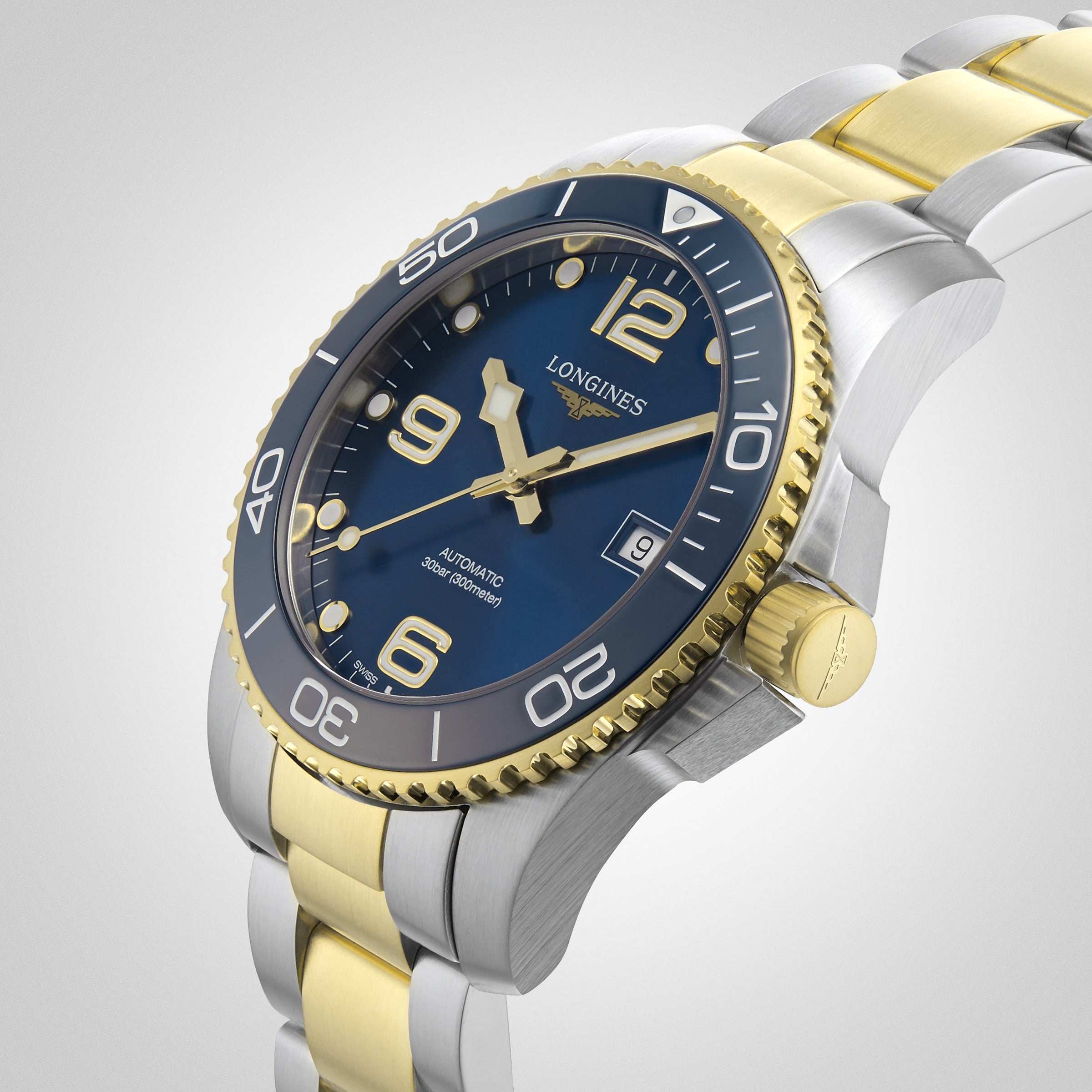 A close-up of the Longines HydroConquest watch, showcasing its blue dial, gold and silver metal band, and unidirectional bezel.