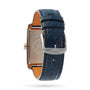 The Longines DolceVita features a rectangular stainless steel case, navy blue leather strap with silver buckle, and an engraved metal case back displaying the Longines logo.