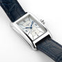 The Longines DolceVita is a rectangular silver wristwatch with a white dial, blue hands, black numerals, date window, dark blue leather strap, and accurate L592 calibre movement.