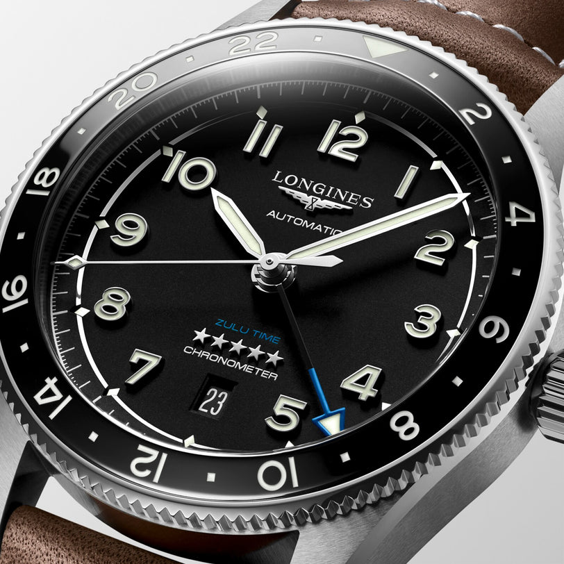 Close-up of the Longines Spirit Zulu Time automatic watch with a black dial, luminous numerals, date display, brown leather strap, stainless steel case, multiple time zone tracking, and chronometer certification.