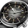 Close-up of the Longines Legend Diver watch with a black dial, bold hour markers, luminous hands, date display, L888 movement, and a grey textile strap.
