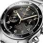 Close-up of the Longines Spirit Flyback automatic chronometer, inspired by aviation heritage, featuring a black dial with gold-tone hands, chronograph subdials, and a stainless steel bracelet.