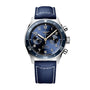 The Longines Spirit Flyback is a men’s wristwatch with a blue dial, chronograph subdials, stainless steel case, rotating bezel, and a blue fabric strap with white stitching.