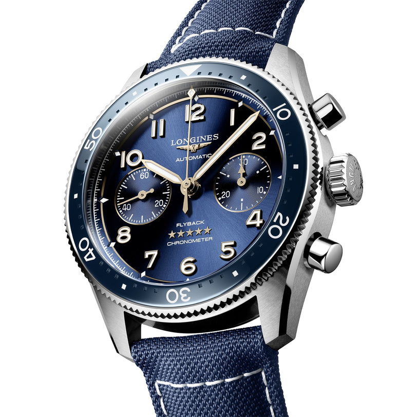 A close-up of the Longines Spirit Flyback, an automatic chronograph with a blue dial, two subdials, blue fabric strap, and stainless steel case.