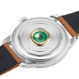 Close-up of the back of a Longines Conquest Heritage automatic Swiss watch with a transparent case showing the precise inner mechanism and a green medallion, along with a partially visible brown leather strap.