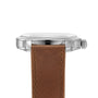 Side view of a Longines Conquest Heritage wristwatch featuring a silver case, round crown, and brown leather strap. This elegant Swiss timepiece’s face is not visible in the image.