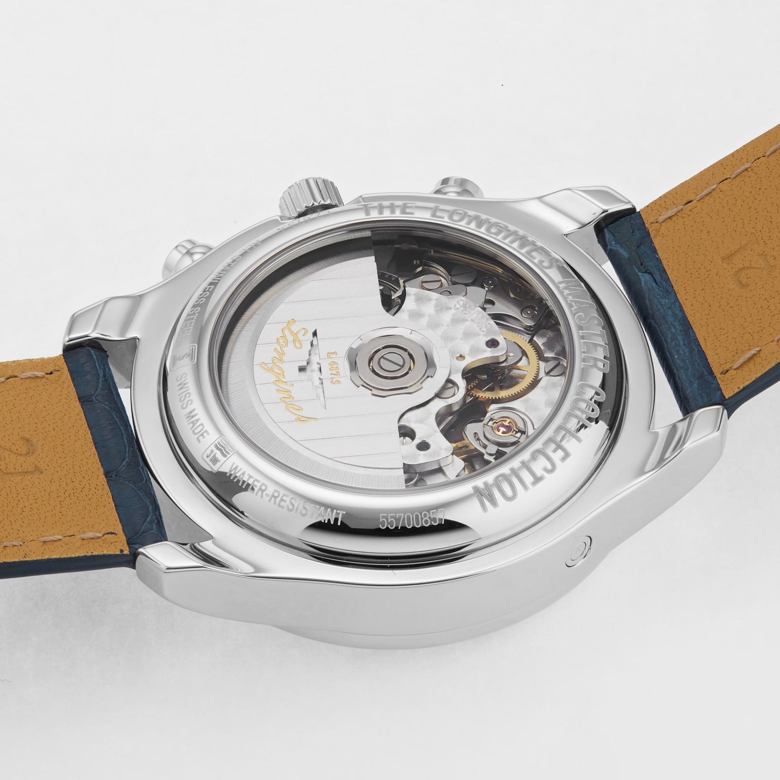 A close-up of the Longines Master Collection Chrono Moonphase showcases its exposed L687 calibre through a transparent case back, with visible leather strap and engraved text reflecting the artistry of fine chronographs.