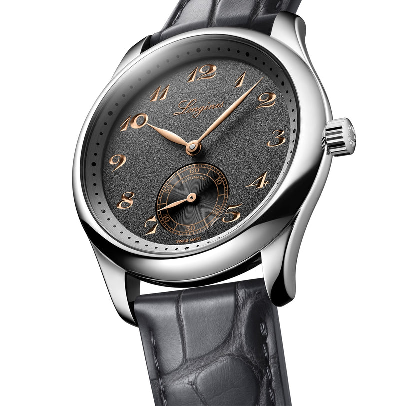 The Longines Master Collection watch features a silver case, black leather strap, anthracite dial with gold Arabic numerals, small seconds at 6 oclock, and is powered by the L893 automatic movement.