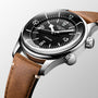 A close-up of the Longines Legend Diver, a vintage-inspired watch with automatic movement, black dial, white markers, dual crowns, and a brown leather strap.