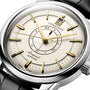 Close-up of the Longines Conquest Heritage Central Power Reserve, featuring a cream dial with gold hour markers and hands, central power reserve display, date window at 12 oclock, black leather strap, and stainless steel case.
