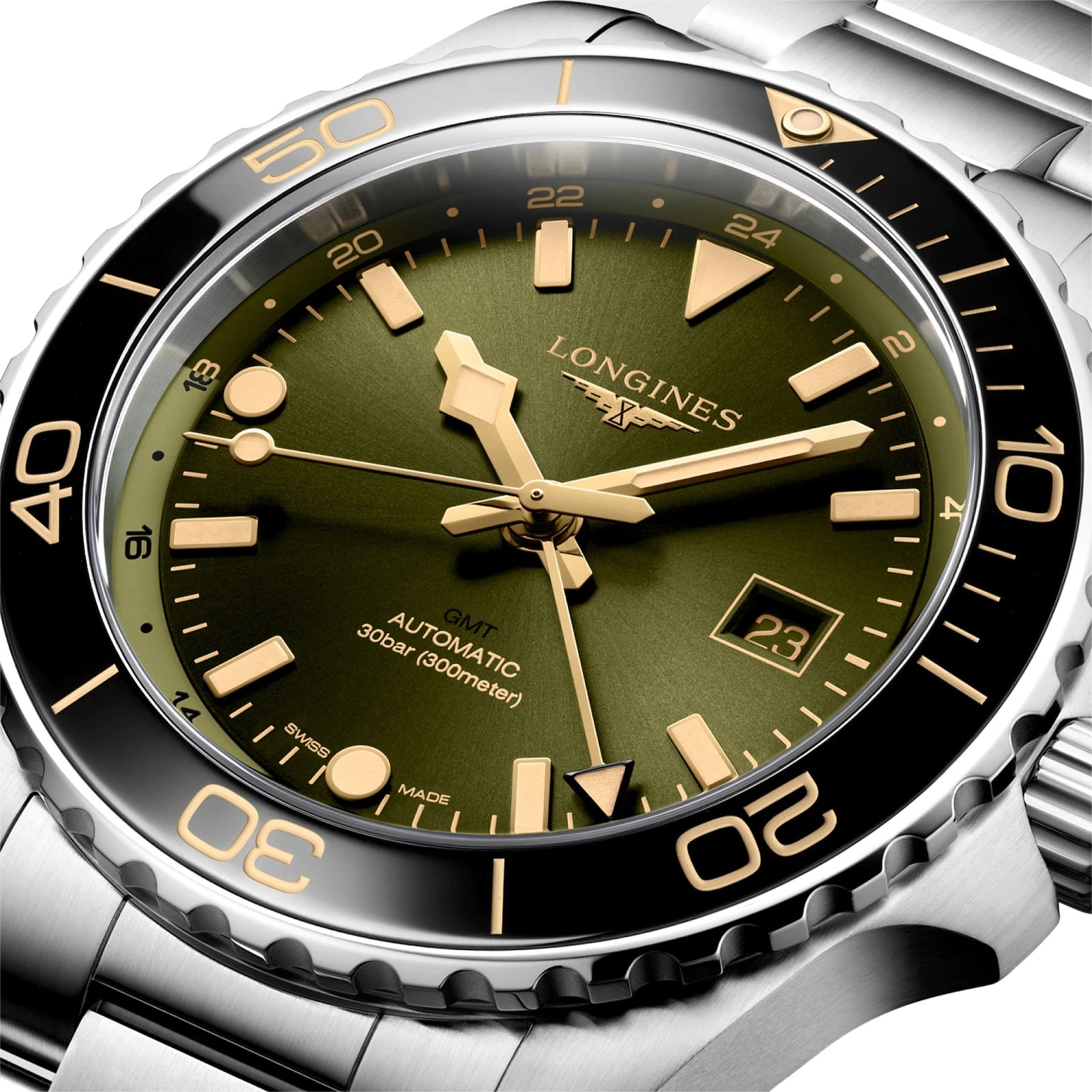 Close-up of the Longines Hydroconquest wristwatch with a green dial, gold-tone markers, date display, black bezel, and stainless steel bracelet. Features GMT functionality and impressive water resistance.