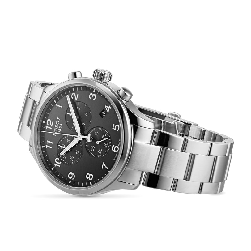 The Tissot Chrono XL Classic wristwatch features Swiss technology, a stainless steel case, black dial with three subdials, date window, and silver hour markers, all stylishly angled.