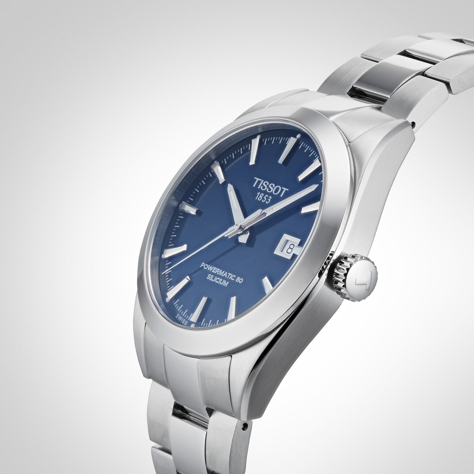 A Tissot Gentleman Powermatic 80 Silicium wristwatch with a blue dial, stainless steel case, silver hour markers, and metal bracelet, shown on a light gray background.