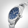 A Tissot Gentleman Powermatic 80 Silicium wristwatch with a blue dial, stainless steel case, silver hour markers, and metal bracelet, shown on a light gray background.
