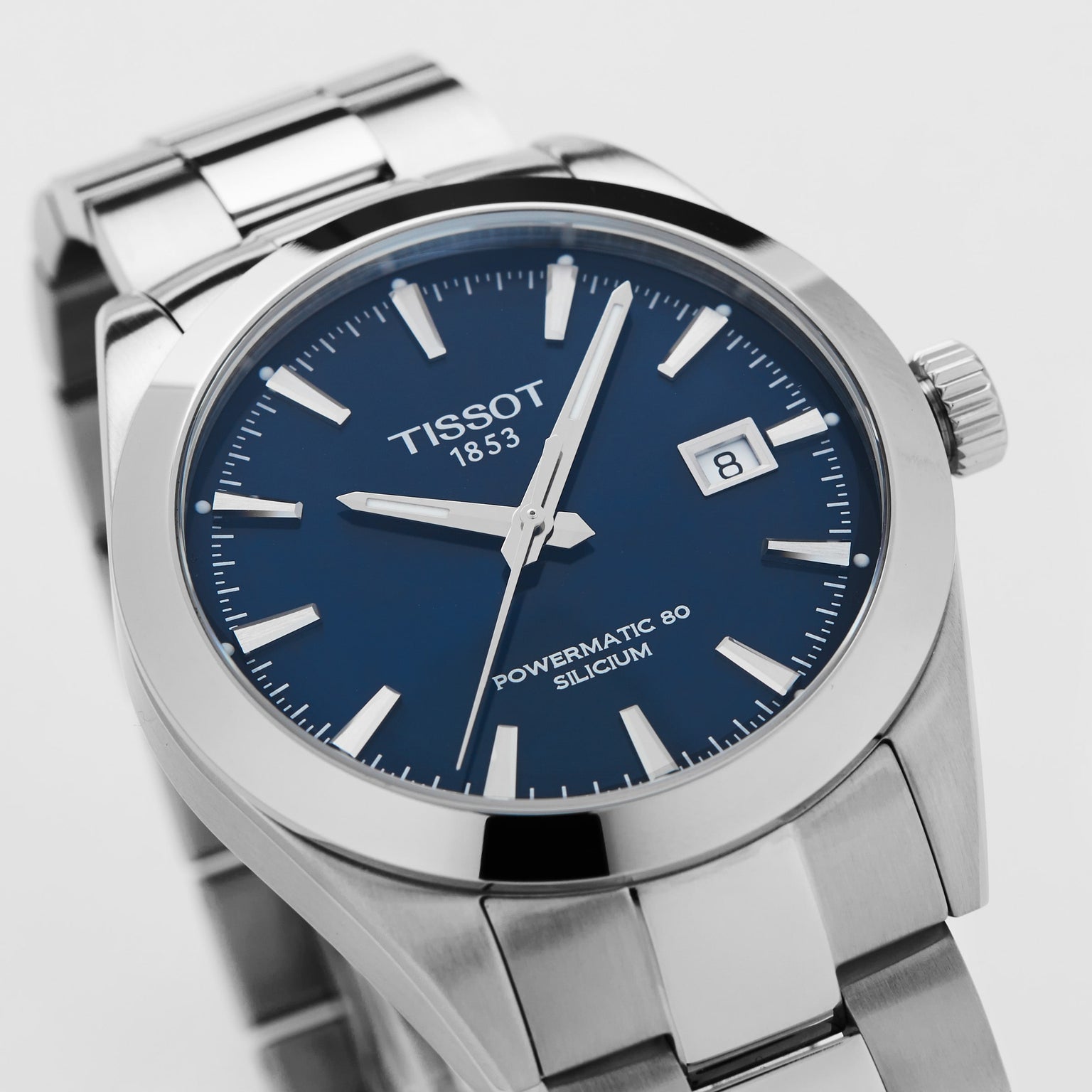 The Tissot Gentleman Powermatic 80 Silicium features a stainless steel case, blue dial, silver hour markers, and a date display set to the 8th—an elegant wristwatch from the Tissot collection.