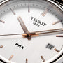 Close-up of the Tissot PRX watch face, highlighting its 1970s-inspired design with the Tissot logo, a date window at 9 o’clock, and sleek silver hour and minute hands.