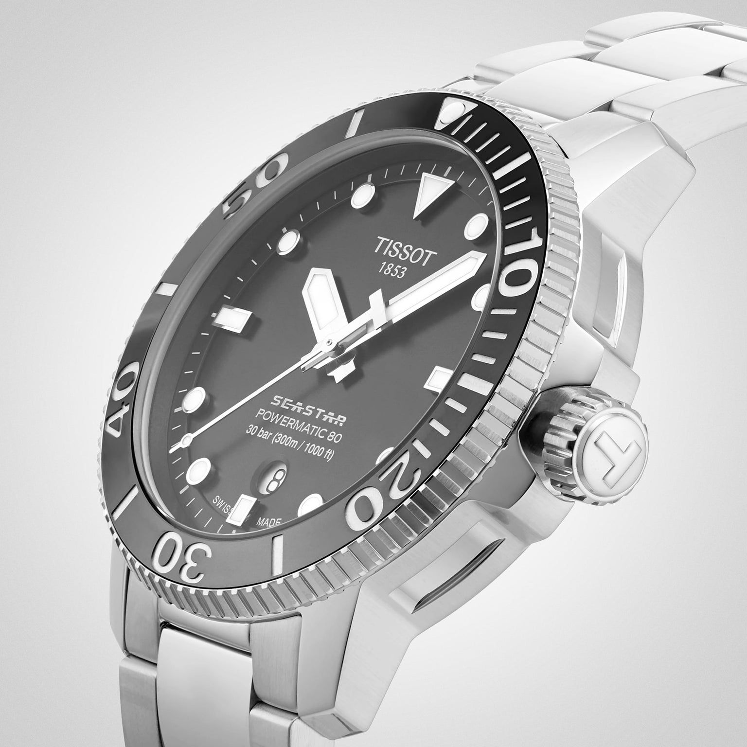Close-up of the Tissot Seastar 1000 Powermatic 80, a stainless steel diver’s watch with black bezel and dial, white hour markers, date display at 6 oclock, and powered by the Powermatic 80 movement.