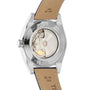 The image displays the back of the Tissot Gentleman Powermatic 80 Silicium Solid 18k Bezel, showcasing its transparent case back, elegant movement, and classic tan leather strap with visible stitching and signature craftsmanship.