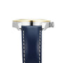Side view of the Tissot Gentleman Powermatic 80 Silicium Solid 18k Bezel watch, featuring a blue leather strap with white stitching, silver case, gold bezel, and ridged crown—luxury meets style powered by the Powermatic 80 movement.