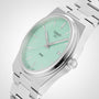 The Tissot PRX features a mint green dial with silver markers and hands, a date window at 3 o’clock, and a stainless steel bracelet for timeless style.