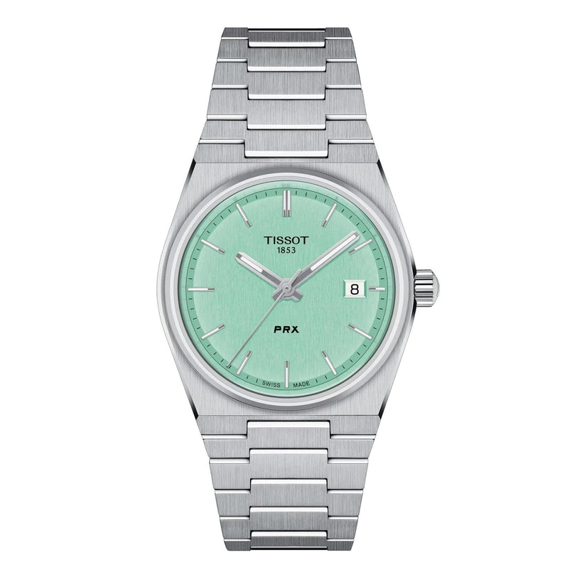 The Tissot PRX features a stainless steel case, mint green dial, silver hour markers and hands, date window at 3 o’clock, and a sleek metal bracelet.