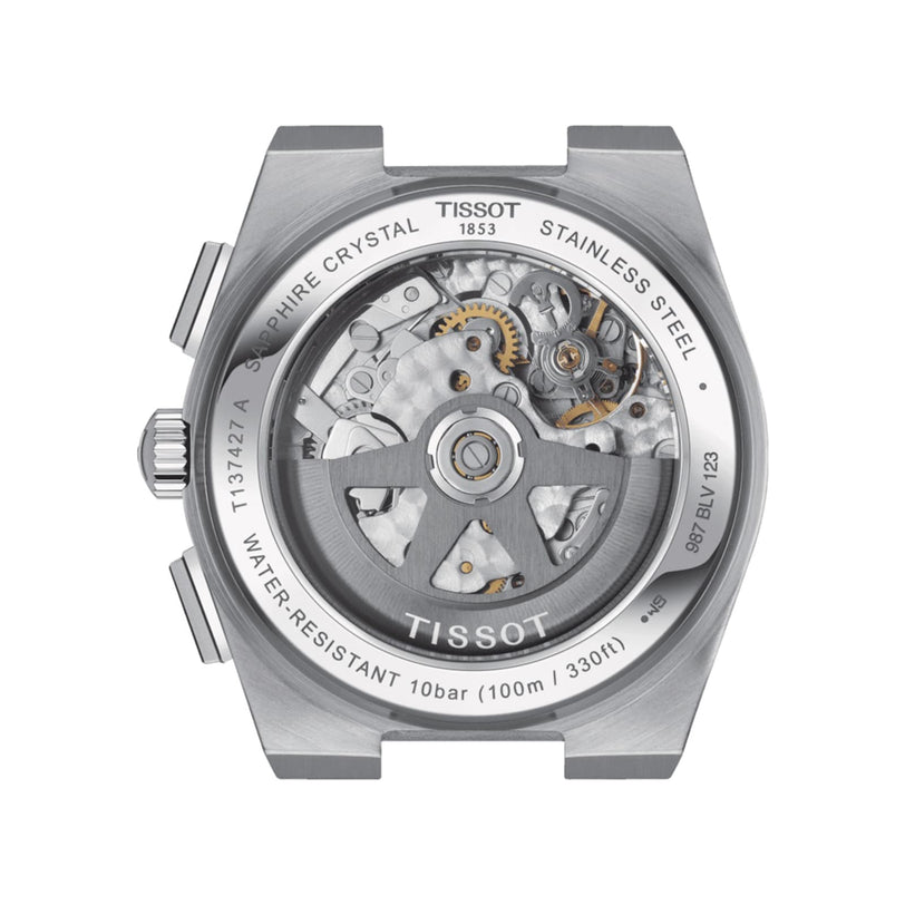 The image shows the back of the Tissot PRX Automatic Chronograph, displaying its mechanical movement through a transparent sapphire crystal caseback with engraved details.