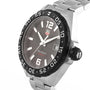 The TAG Heuer Formula 1 Date watch features a stainless steel case, black bezel, steel band, dark dial with date display, and large numerals at 6 and 12 o’clock.