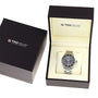 A TAG Heuer Formula 1 Date watch with a metal band and tachymeter bezel is presented in an open black and cream box, accompanied by a closed box, both showing the TAG Heuer logo.