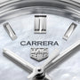 Close-up of a TAG Heuer Carrera Date watch face with silver hour markers and hands, plus the TAG Heuer logo on a light, textured mother-of-pearl dial.