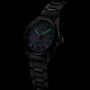 The TAG Heuer Carrera Date is a black luxury wristwatch with green glowing hands and markers, set against a dark background.