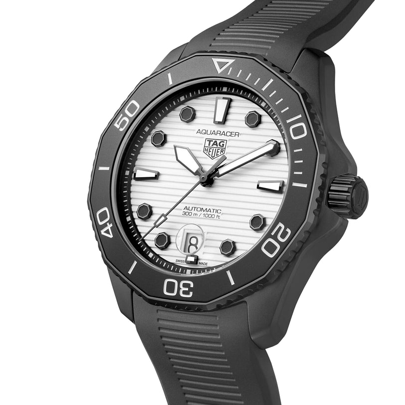 A close-up of the TAG Heuer Aquaracer Professional 300 Date watch featuring a black bezel, white textured dial, black markers, and a black rubber strap.