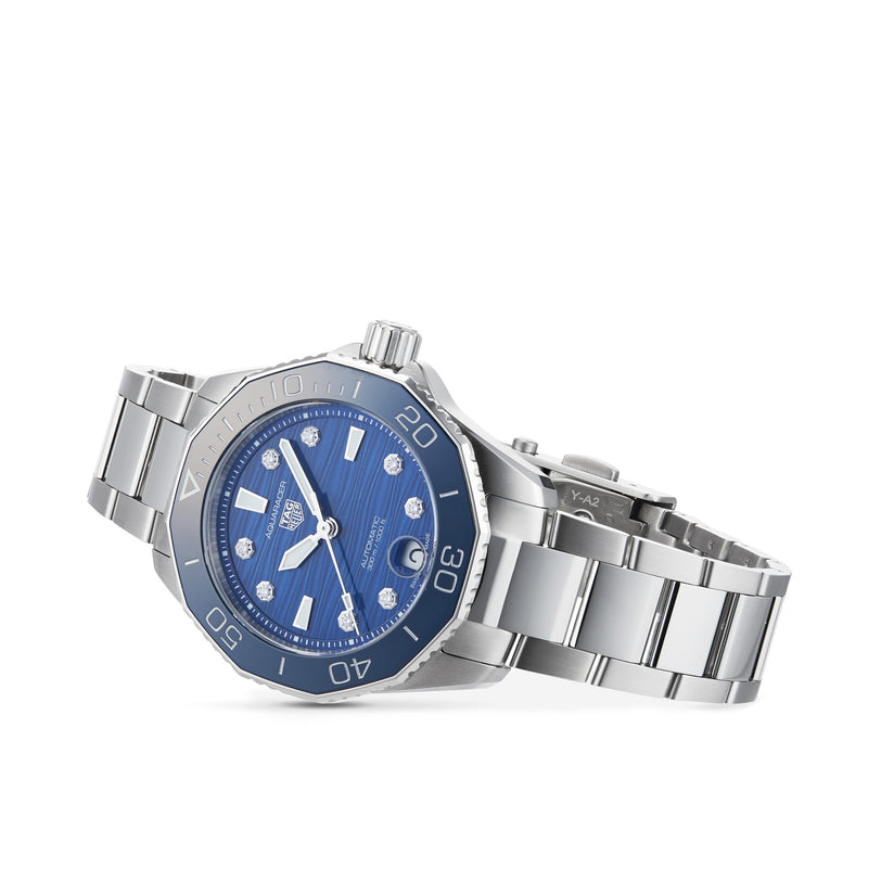 The TAG Heuer Aquaracer Professional 300 Date, a stainless steel dive watch with a blue dial, diamond hour markers, and a unidirectional bezel, is displayed at an angle on a white background.