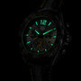 The TAG Heuer Special Edition Formula 1 Senna wristwatch features luminescent green markers and hands, a black case, leather strap with yellow stitching, and multiple subdials, all inspired by Ayrton Senna and shown in a dark setting.