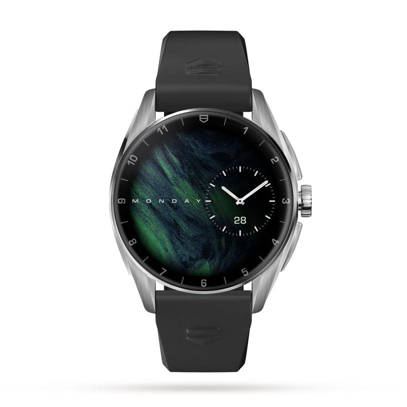 The TAG Heuer Connected Calibre E4 is a modern luxury smartwatch with a round face, ergonomic rubber strap, silver casing, and a digital display showing the day, date, and time on a sleek dark background.