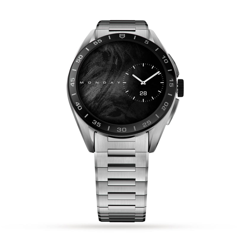 The TAG Heuer Connected Calibre E4 is a silver stainless steel luxury smartwatch with a black face showing day, date, and time in an avant-garde design, set against a white background.