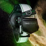 The TAG Heuer Connected Calibre E4 Golf Edition smartwatch with a white strap is shown from the back, surrounded by green and gold powder.