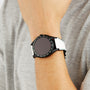 A person wearing a TAG Heuer Connected Calibre E4 Golf Edition with a round face and white strap on their left wrist.
