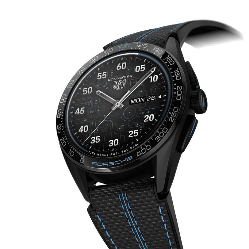 The TAG Heuer Connected Calibre E4 Porsche Edition is a luxury smartwatch with a black case, digital display, and black textured strap accented by blue stitching.
