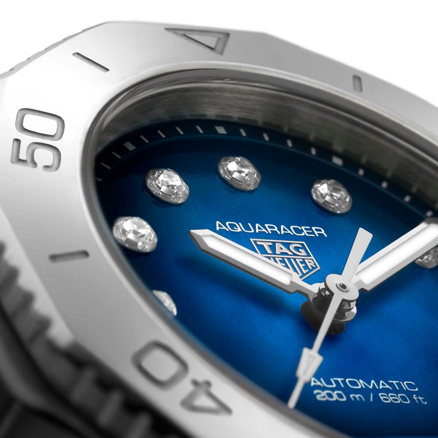 Close-up of a TAG Heuer Aquaracer Professional 200 Date watch with a blue dial, diamond hour markers, and Automatic 200 m / 660 ft text, all set in a sleek stainless steel case.