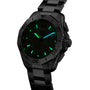 The TAG Heuer Aquaracer Professional 200 Chronograph features glowing green and blue luminescent hour markers and hands on a black dial with a metal band, highlighting its high-performance design in low-light conditions.