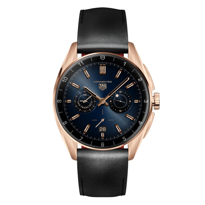 The TAG Heuer Connected Calibre E4 Golden Bright Edition features a black leather strap, blue dial, gold hour markers, subdials, and a date window at 6 o’clock, presented on a plain white background.