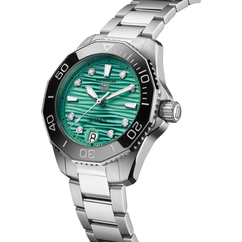 The TAG Heuer Aquaracer Professional 300 Date is a stainless steel sports watch with a silver strap, black bezel, and turquoise textured dial adorned with diamond hour markers.