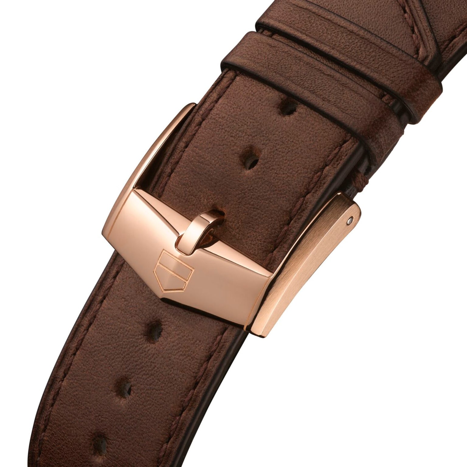 Close-up of a brown leather strap with gold-toned buckle and engraved shield logo on the TAG Heuer Special Edition Carrera Chronosprint x Porsche, inspired by the Porsche 911s automatic chronograph movement.