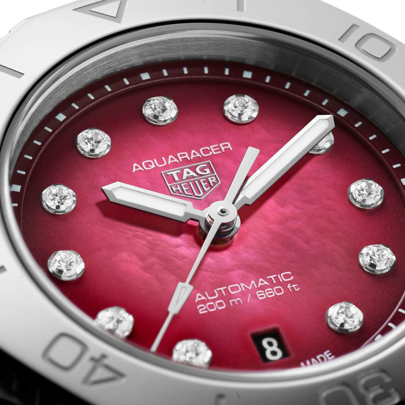 Close-up of the TAG Heuer Aquaracer Professional 200 Date with a bold red dial, diamond hour markers, date window at 3 o’clock, and silver numeral bezel—showcasing sporty elegance from TAG Heuer.