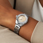 A TAG Heuer Aquaracer Professional 200 Date wristwatch with a beige dial and diamond hour markers on a persons wrist.